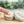 Load image into Gallery viewer, the little flower soap co skin rescue balm 1 oz tin open and someone is dipping finger in to use
