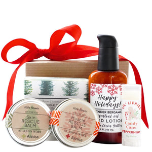 Gift set with skin rescue balms, lotion, and lip balm with a red ribbon on a white background